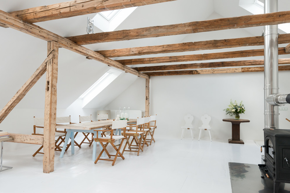 Idée de décoration pour une salle à manger ouverte sur le salon design avec un mur blanc, un poêle à bois, un manteau de cheminée en métal et un sol en linoléum.