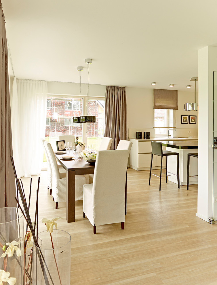 Идея дизайна: большая гостиная-столовая в стиле модернизм с белыми стенами, светлым паркетным полом и коричневым полом
