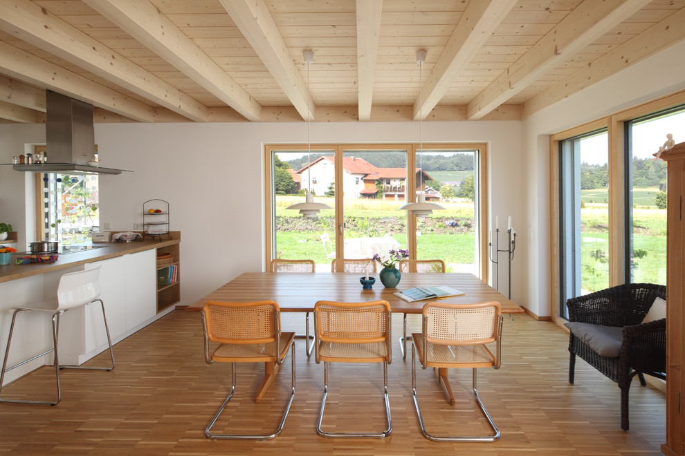 Mittelgroße Moderne Wohnküche ohne Kamin mit weißer Wandfarbe, hellem Holzboden und beigem Boden in München