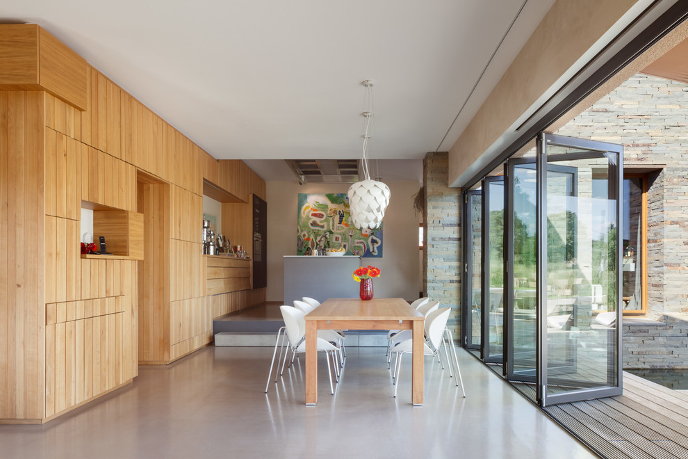 Große Moderne Wohnküche ohne Kamin mit Betonboden, grauem Boden und weißer Wandfarbe in Essen