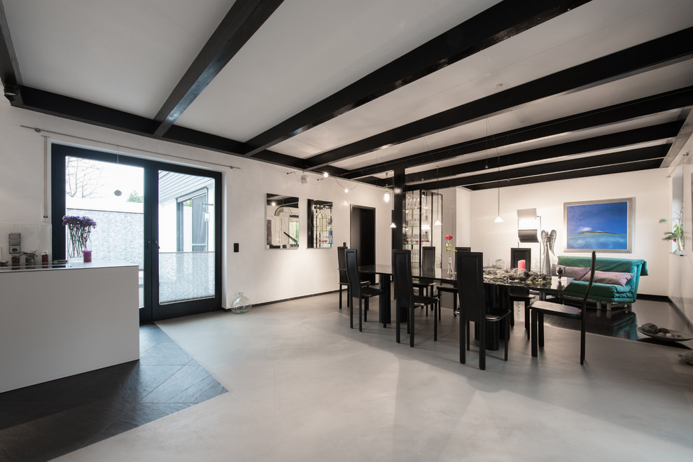 Offenes, Großes Modernes Esszimmer ohne Kamin mit weißer Wandfarbe, Betonboden und grauem Boden in Köln