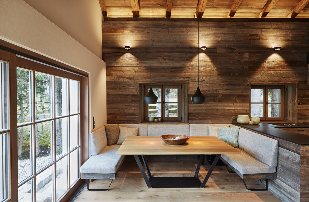 Cette photo montre une salle à manger montagne fermée et de taille moyenne avec un sol en bois brun, un mur marron et un sol marron.