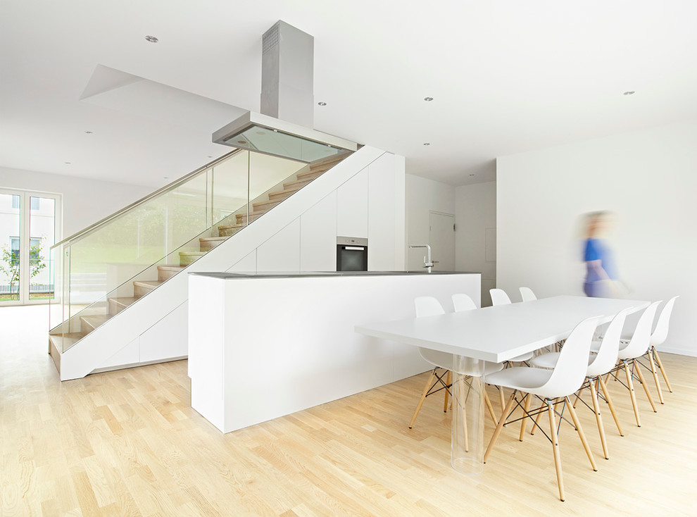 Идея дизайна: кухня-столовая в скандинавском стиле с белыми стенами и светлым паркетным полом