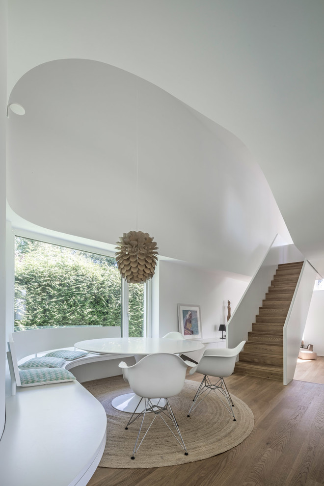 Пример оригинального дизайна: гостиная-столовая среднего размера в стиле модернизм с белыми стенами, паркетным полом среднего тона и коричневым полом без камина