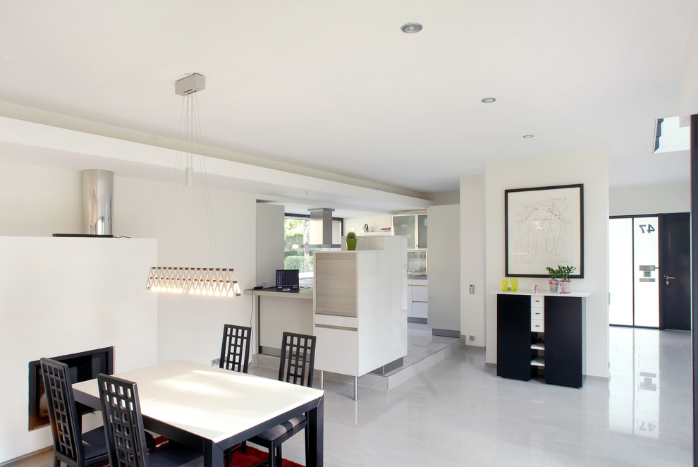 На фото: гостиная-столовая среднего размера в стиле модернизм с белыми стенами, полом из керамогранита и белым полом с