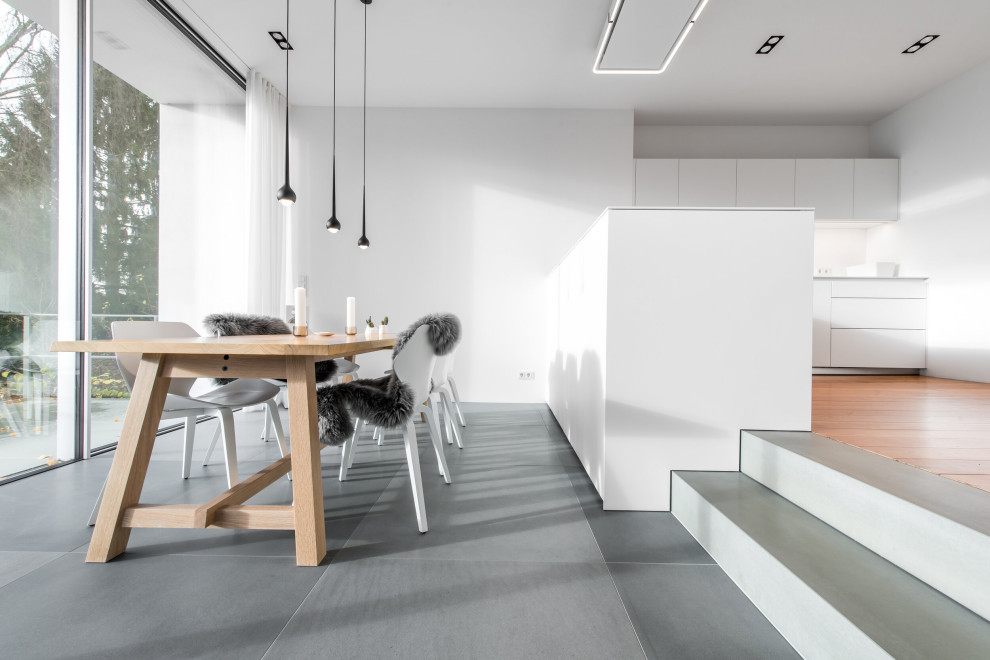 Ispirazione per una sala da pranzo aperta verso il soggiorno moderna di medie dimensioni con pareti bianche e pavimento in pietra calcarea