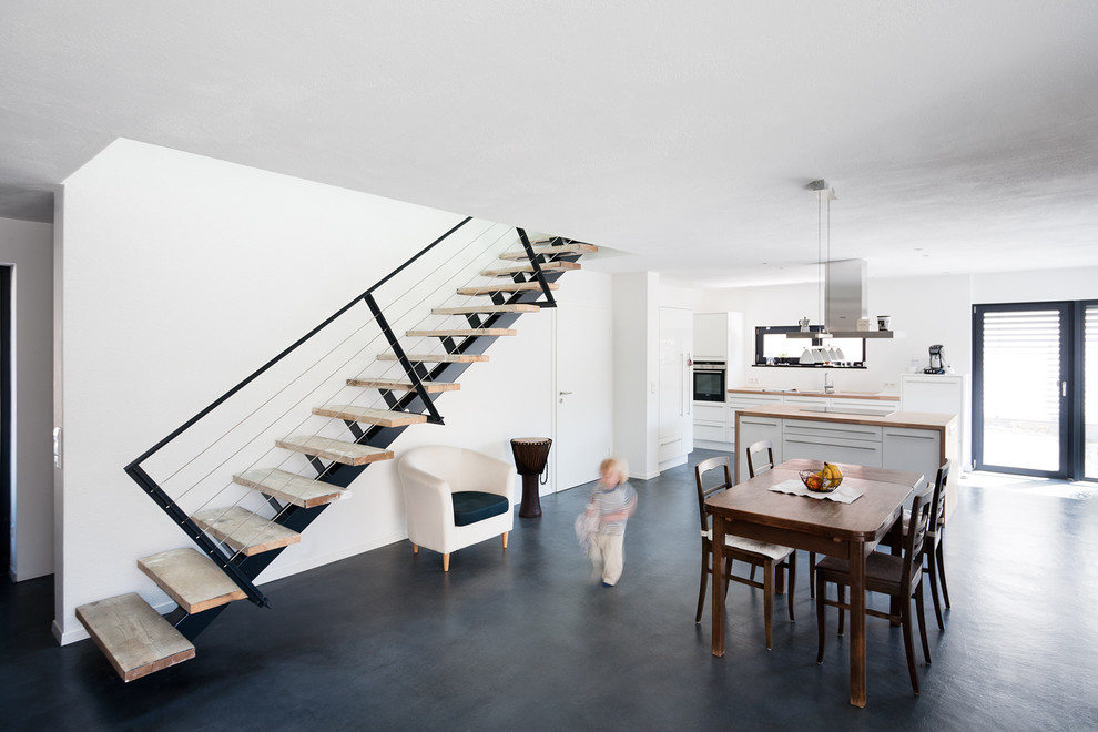 Große Moderne Wohnküche ohne Kamin mit weißer Wandfarbe und Vinylboden in Stuttgart