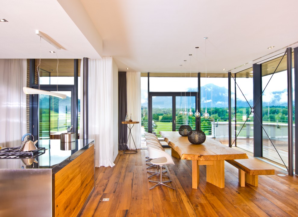 Imagen de comedor contemporáneo grande abierto con suelo de madera en tonos medios