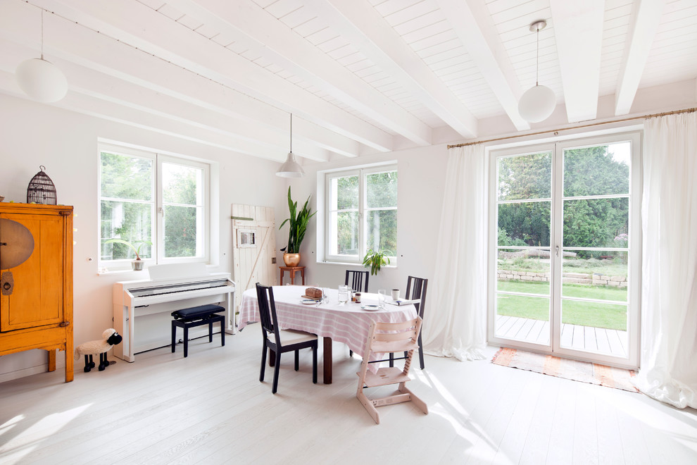 Cette photo montre une salle à manger ouverte sur la cuisine nature de taille moyenne avec un mur blanc, parquet clair et aucune cheminée.