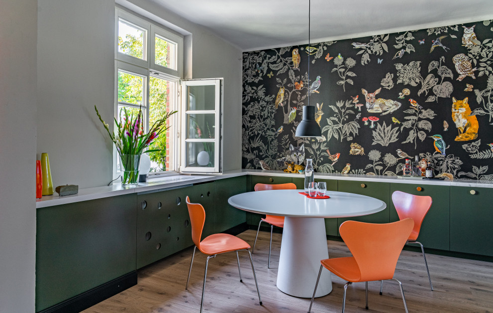 Ispirazione per una piccola sala da pranzo aperta verso la cucina industriale con pareti nere e parquet chiaro