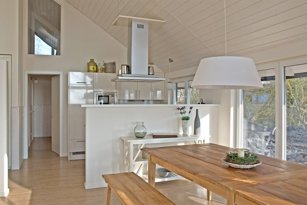 Large scandi kitchen/dining room in Berlin with white walls and vinyl flooring.