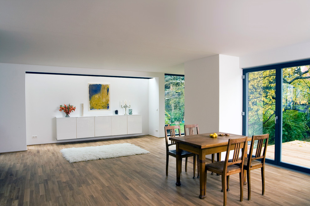 Design ideas for a large contemporary open plan dining room in Stuttgart with white walls and dark hardwood flooring.