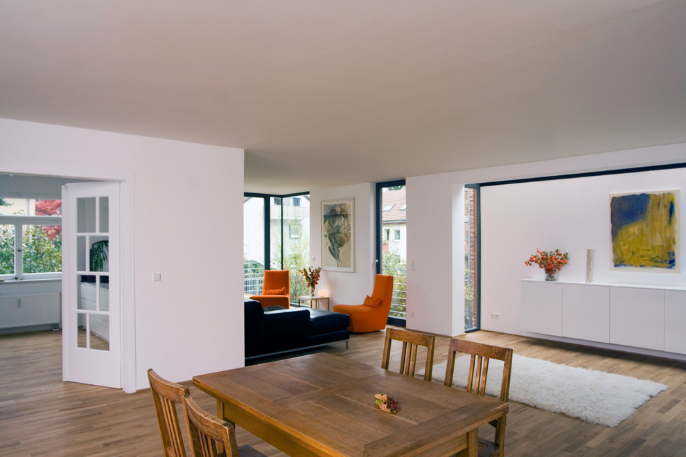 Dining room - contemporary medium tone wood floor dining room idea in Stuttgart with white walls