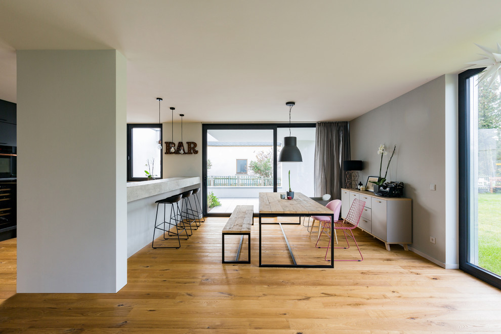 Mittelgroßes Modernes Esszimmer ohne Kamin mit grauer Wandfarbe, hellem Holzboden und braunem Boden in Leipzig