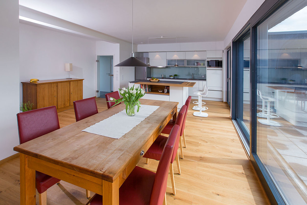 Ispirazione per una grande sala da pranzo contemporanea con pareti bianche e parquet chiaro