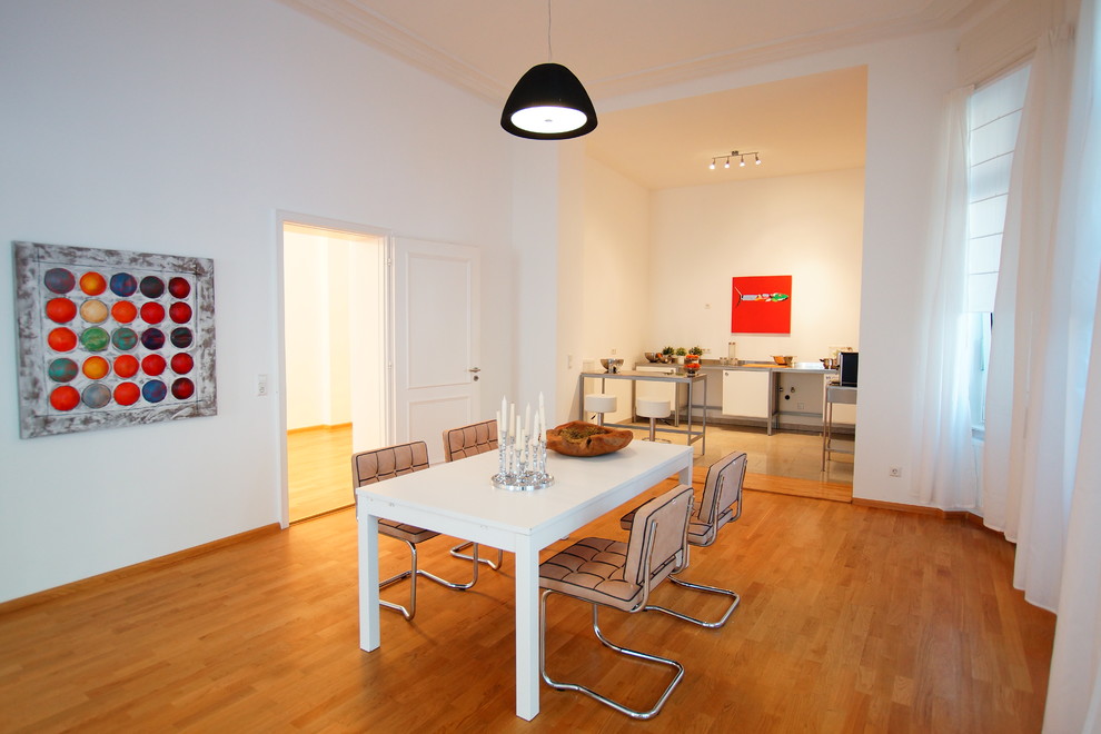 Ispirazione per una sala da pranzo contemporanea chiusa e di medie dimensioni con pavimento in legno massello medio e pareti bianche