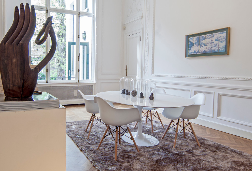 Photo of a large contemporary enclosed dining room in Brussels with white walls and medium hardwood flooring.