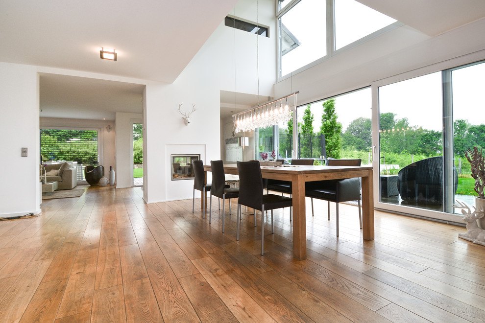 Inspiration for a large contemporary open plan dining room in Essen with white walls and medium hardwood flooring.