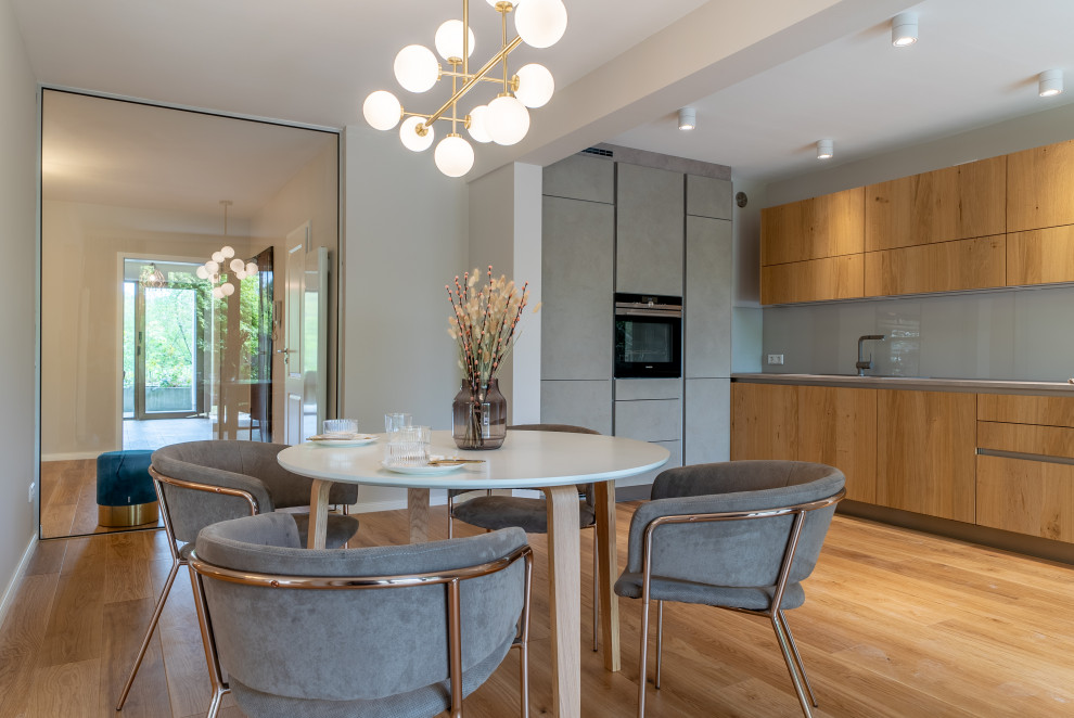 Mittelgroße Moderne Wohnküche mit grauer Wandfarbe und braunem Boden in Hannover