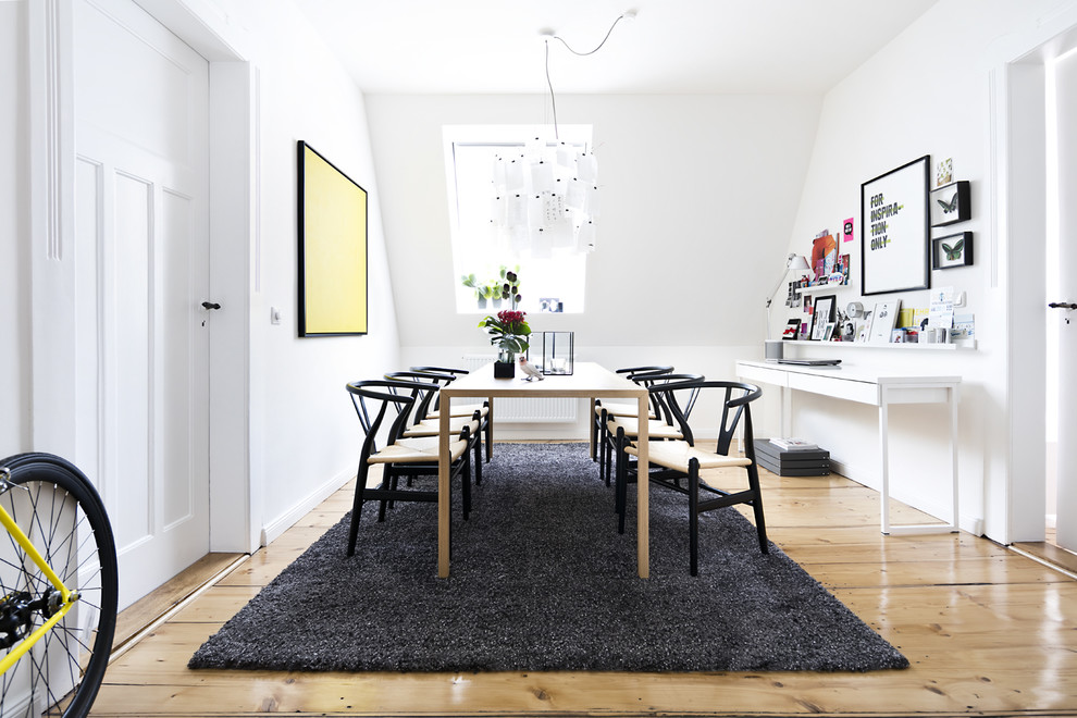 Cette image montre une salle à manger nordique fermée et de taille moyenne avec un mur blanc, parquet clair et un sol beige.