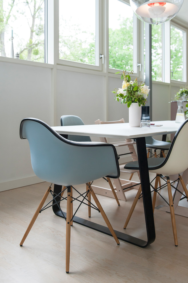 Design ideas for a scandinavian dining room in Berlin with light hardwood flooring.