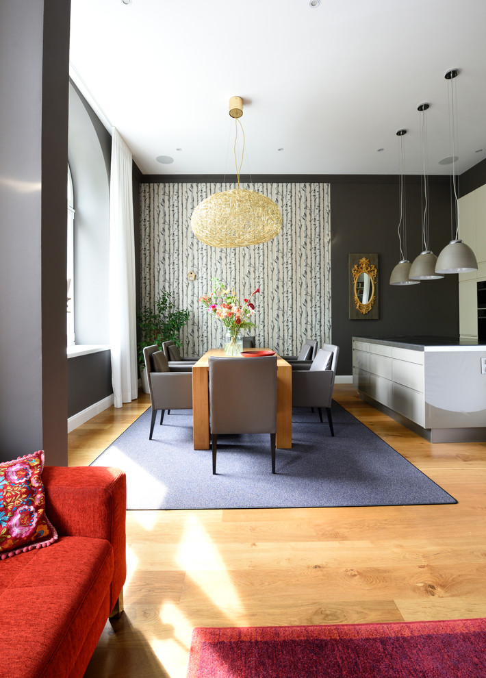 Immagine di un'ampia sala da pranzo aperta verso il soggiorno eclettica con pareti grigie, pavimento in legno massello medio e pavimento beige