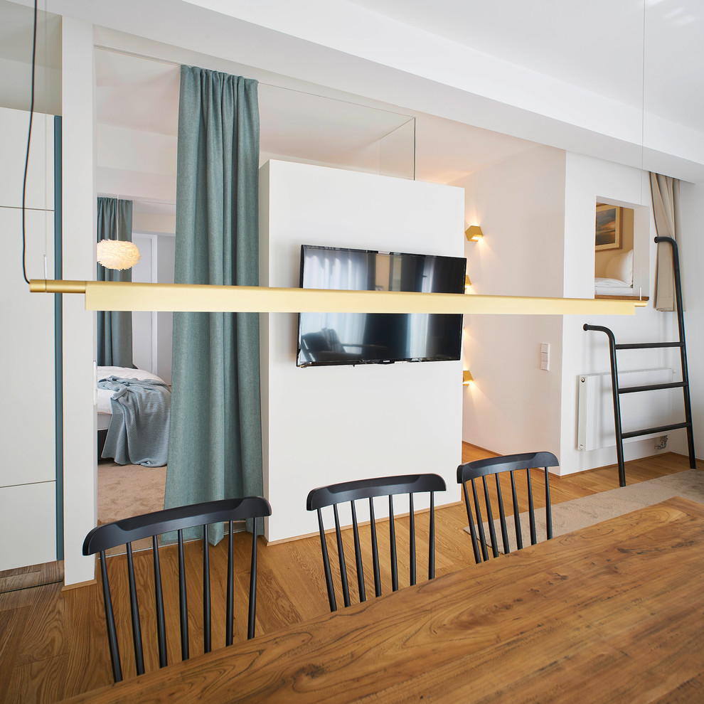 Exemple d'une salle à manger ouverte sur la cuisine tendance de taille moyenne avec un mur blanc, un sol en bois brun et un sol beige.