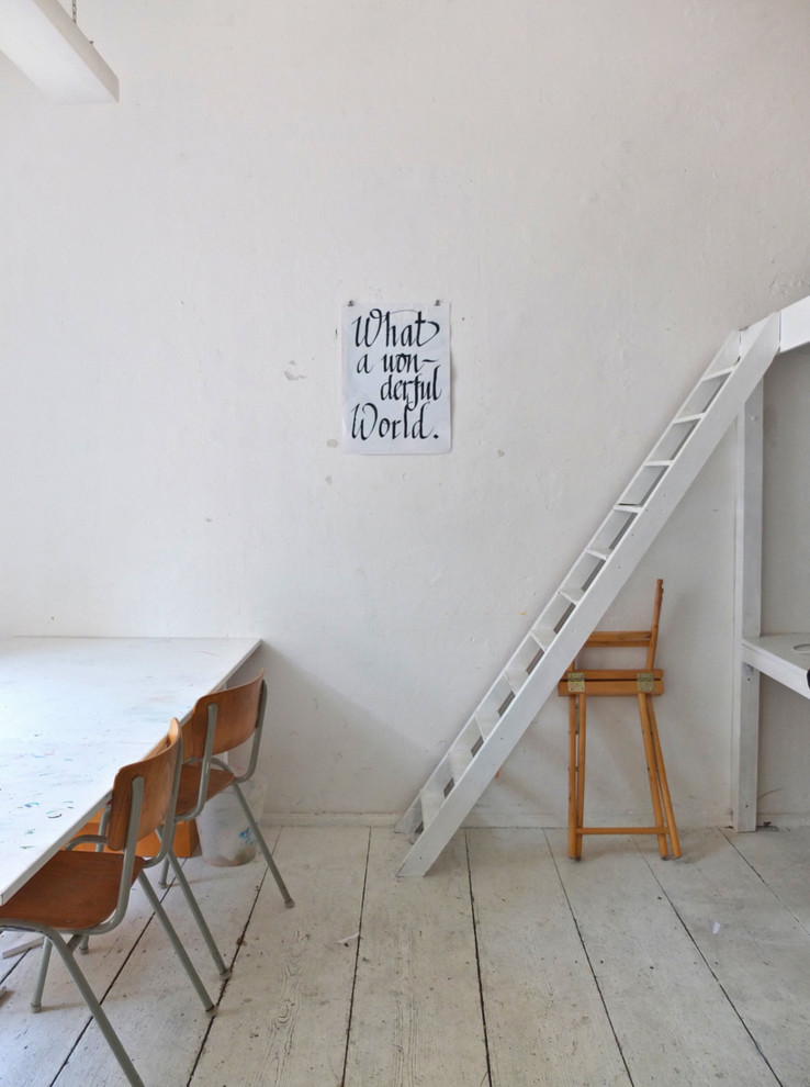 Skandinavisches Esszimmer mit weißer Wandfarbe und gebeiztem Holzboden in Berlin