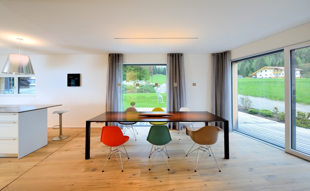 Exemple d'une grande salle à manger ouverte sur le salon tendance avec un mur blanc, un sol en bois brun et aucune cheminée.