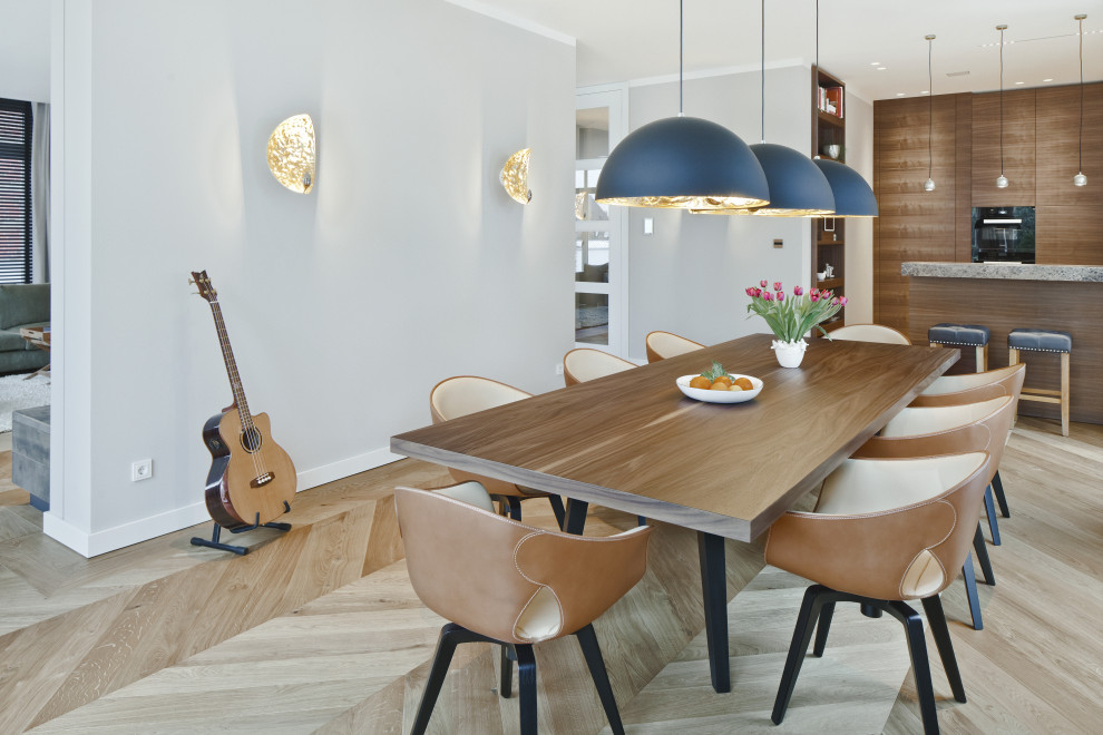 Idée de décoration pour une salle à manger ouverte sur le salon design avec un mur gris, parquet clair et un sol beige.