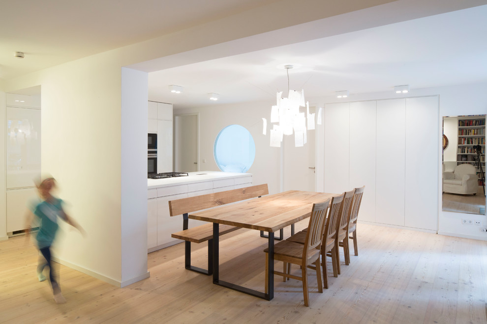 Mittelgroße Moderne Wohnküche ohne Kamin mit weißer Wandfarbe, hellem Holzboden und beigem Boden in München