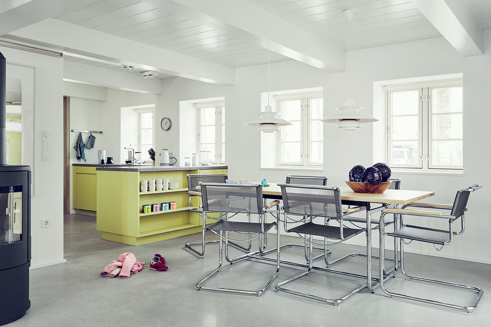 Exemple d'une salle à manger ouverte sur la cuisine scandinave de taille moyenne avec un mur blanc et sol en béton ciré.