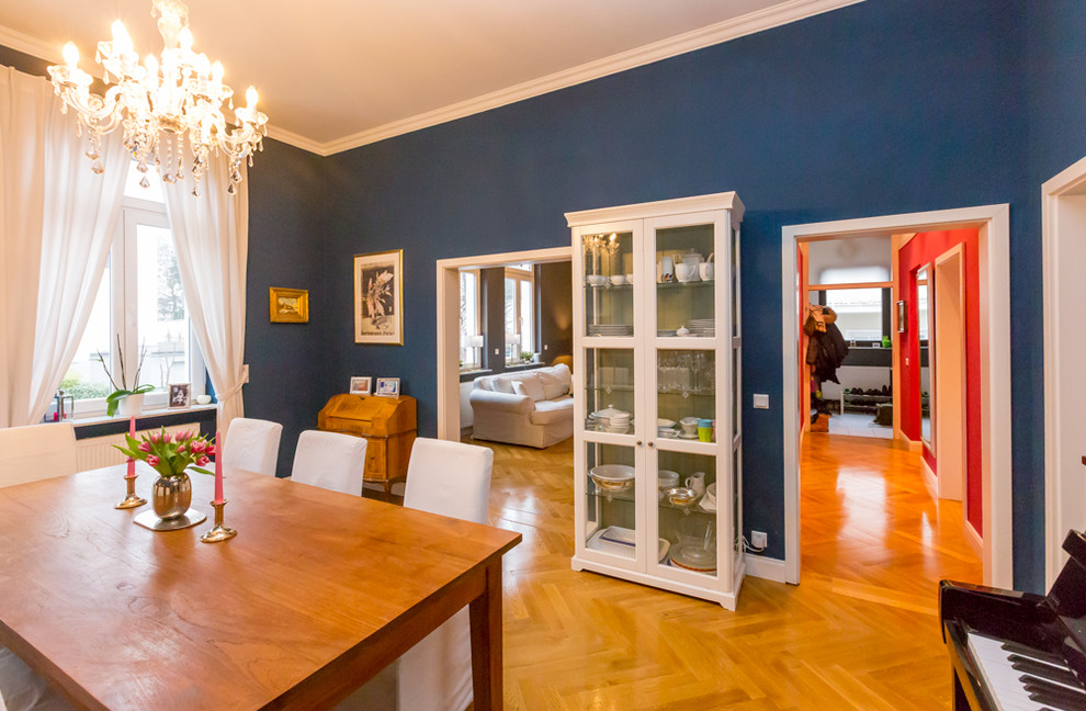 Foto di una sala da pranzo tradizionale con pareti blu e pavimento in legno massello medio