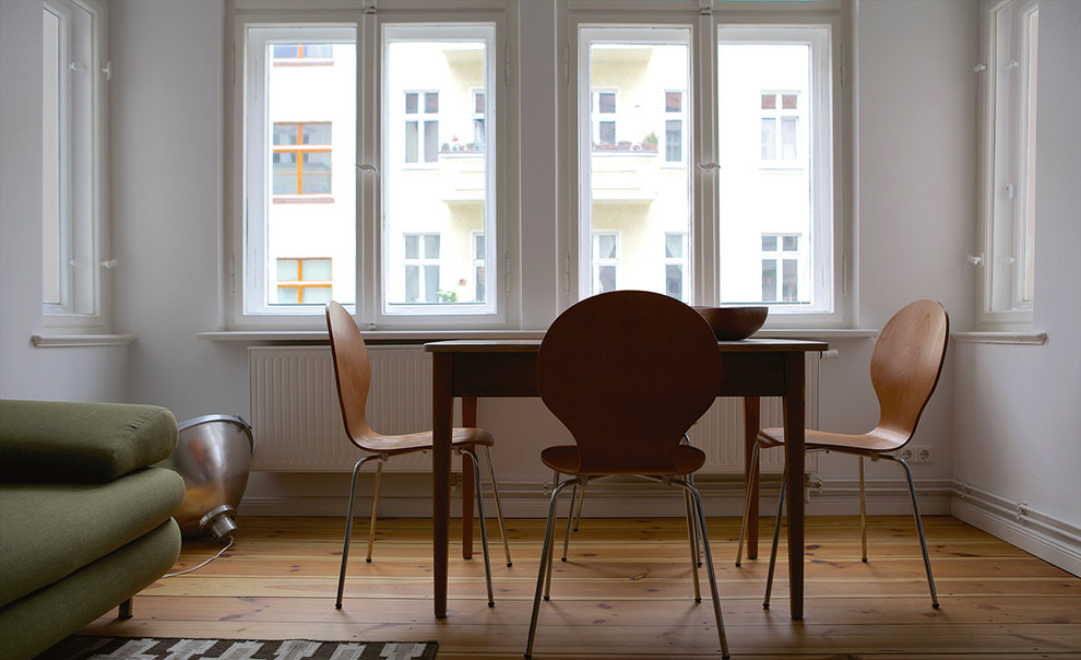 Dining room - contemporary medium tone wood floor dining room idea in Berlin with white walls