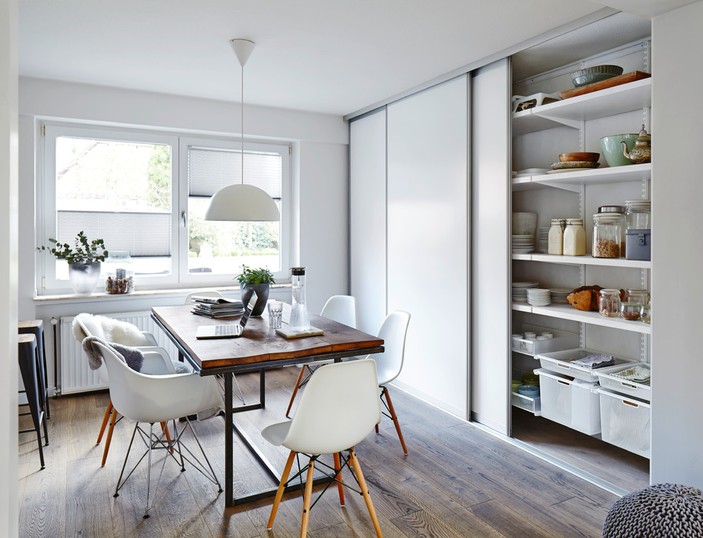 Esempio di una sala da pranzo aperta verso la cucina minimal di medie dimensioni con pavimento in legno massello medio e pareti bianche