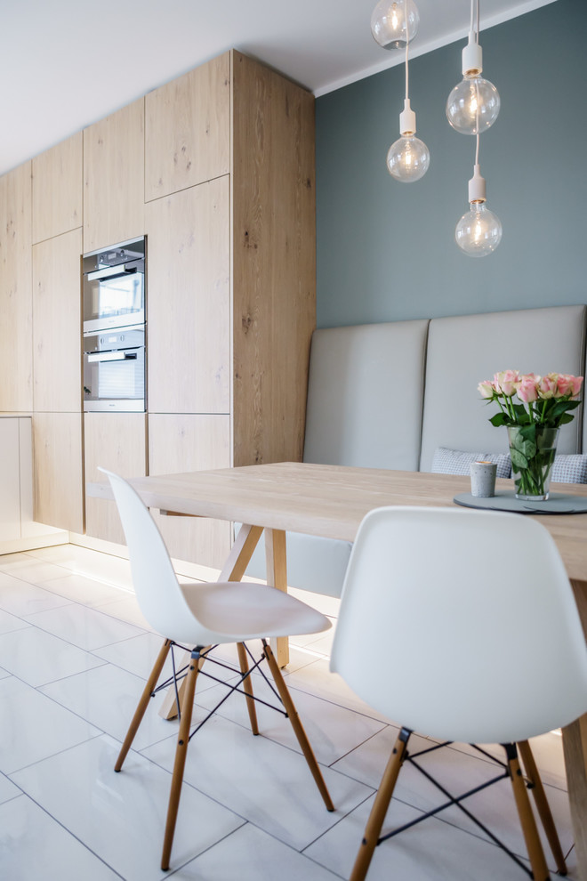 Immagine di una piccola sala da pranzo aperta verso la cucina scandinava con pareti blu, pavimento in marmo, nessun camino e pavimento bianco