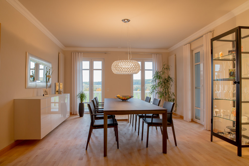 Photo of a large contemporary enclosed dining room in Munich with beige walls and light hardwood flooring.