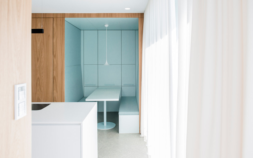 Esempio di una piccola sala da pranzo aperta verso la cucina moderna con pareti blu, pavimento in cemento e pavimento grigio