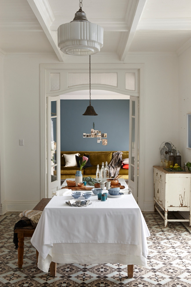 Imagen de comedor romántico con paredes azules y suelo de baldosas de porcelana