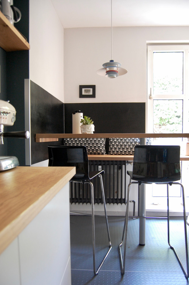 Kleine Moderne Wohnküche ohne Kamin mit weißer Wandfarbe und grauem Boden in Berlin