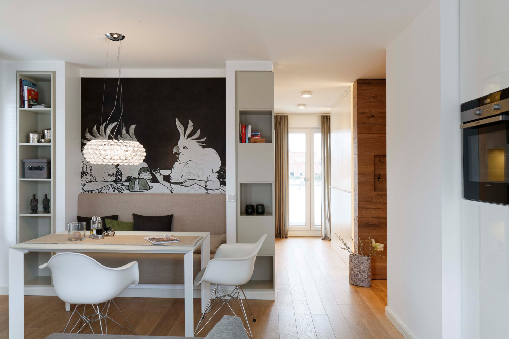 Offenes Modernes Esszimmer mit weißer Wandfarbe, braunem Holzboden und braunem Boden in Sonstige