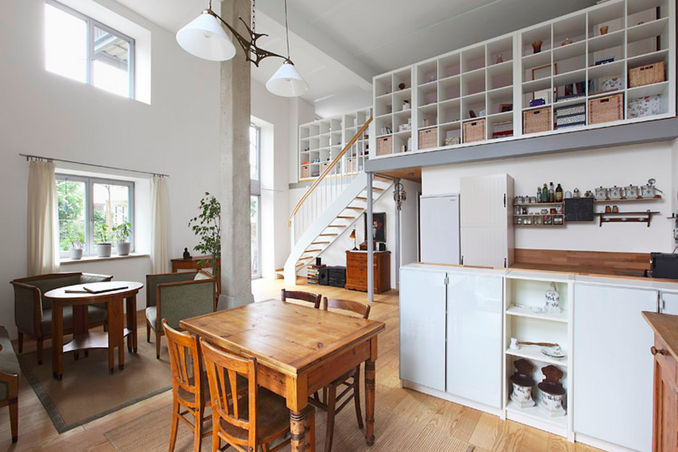 Foto de comedor de cocina industrial con paredes blancas y suelo de madera clara