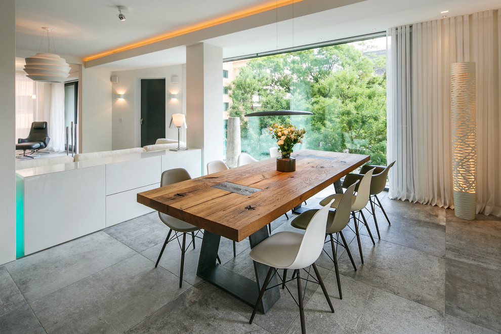 Exemple d'une salle à manger ouverte sur le salon tendance de taille moyenne avec un mur blanc, aucune cheminée, sol en béton ciré et éclairage.