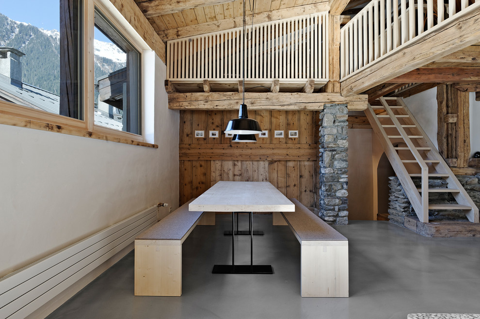 Photo of a rustic open plan dining room in Stuttgart with white walls and concrete flooring.