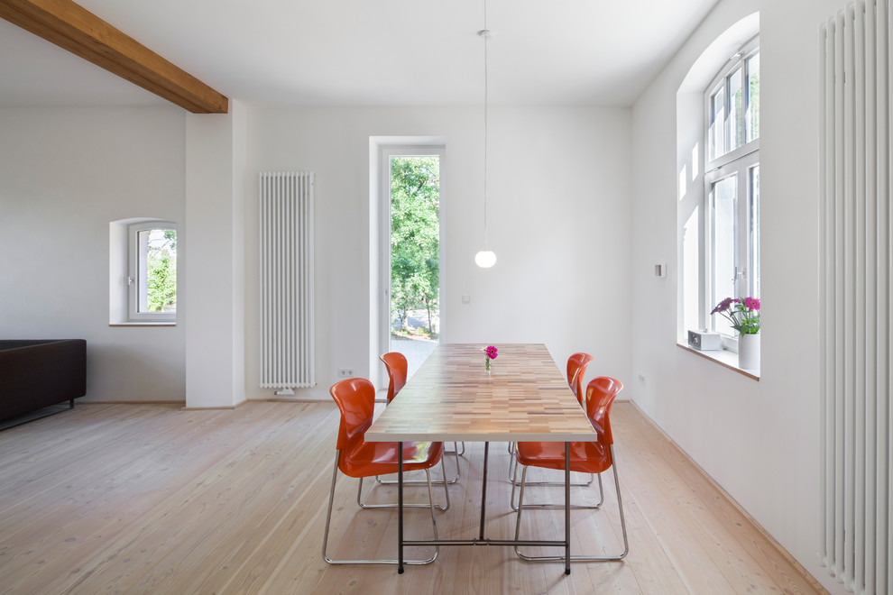 Foto de comedor actual grande abierto con paredes blancas y suelo de madera clara