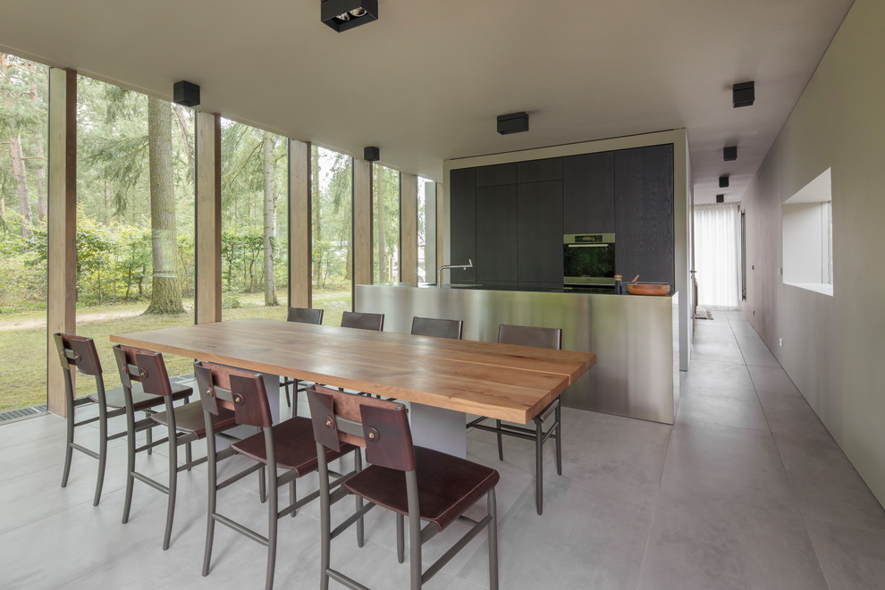 Bild på ett stort funkis kök med matplats, med vita väggar, betonggolv och grått golv