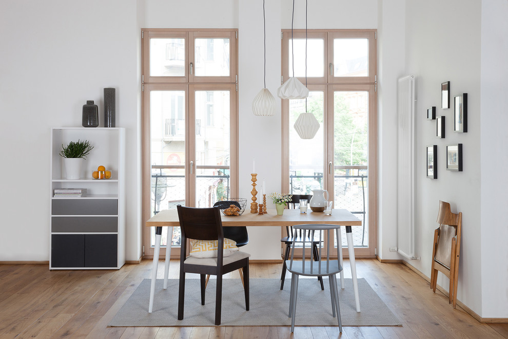 Inspiration pour une salle à manger ouverte sur le salon nordique de taille moyenne avec un mur blanc et un sol en bois brun.