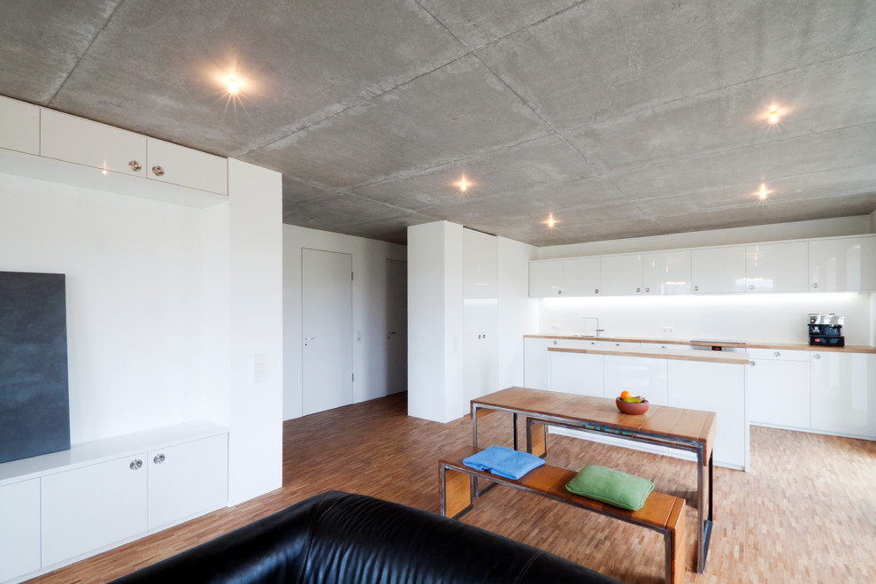 Idee per una sala da pranzo aperta verso il soggiorno contemporanea di medie dimensioni con pareti bianche e pavimento in legno massello medio