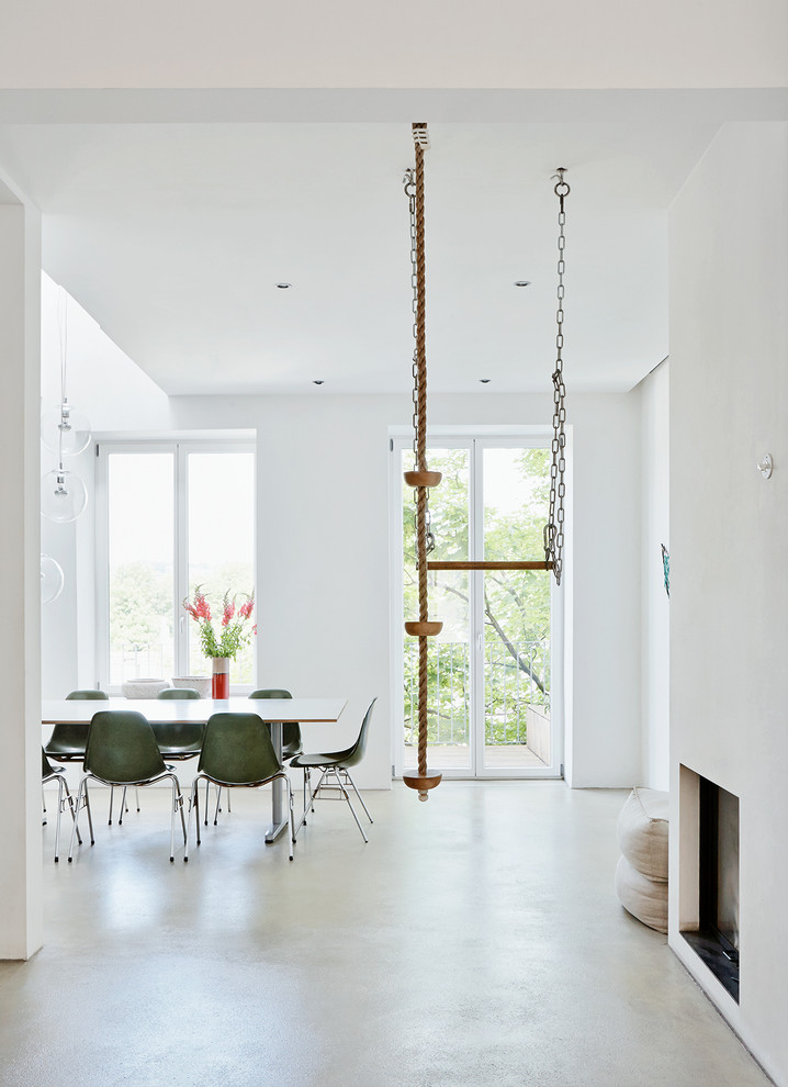 Idee per una sala da pranzo moderna di medie dimensioni con pareti bianche e pavimento in cemento