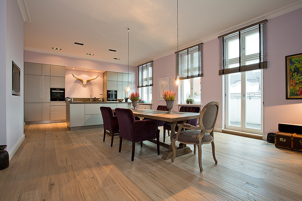 Immagine di una grande sala da pranzo aperta verso il soggiorno chic con pareti viola e pavimento in legno massello medio